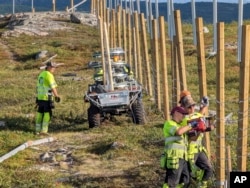 People work to build a new fence along the border with Russia, next to Storskog, Norway, Aug. 23, 2023.