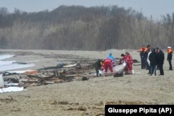 Tim penyelamat menemukan jenazah setelah perahu migran pecah di laut lepas, di pantai dekat Cutro, Italia selatan, Minggu, 26 Februari 2023. (Foto: AP/Giuseppe Pipita)