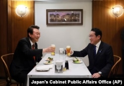 Presiden Korea Selatan Yoon Suk Yeol (kiri) dan Perdana Menteri Jepang Fumio Kishida sedang menikmati hidangan di sebuah restoran di kawasan Ginza, Tokyo, Jepang, 16 Maret 2023. (Foto: Kantor Urusan Umum Kabinet Jepang via Associated Press)