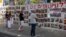 Personas se detienen delante de una pared con carteles en apoyo de los rehenes que fueron secuestrados durante el mortal ataque del 7 de octubre contra Israel por parte del grupo islamista palestino Hamás, en Tel Aviv, Israel, el 23 de abril de 2024.