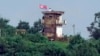 A North Korean soldier stands at the North's military guard post as a North Korean flag flutters in the wind, in this view from Paju, South Korea, July 24, 2024.