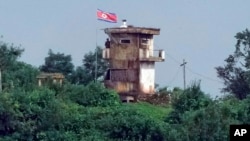 A North Korean soldier stands at the North's military guard post as a North Korean flag flutters in the wind, in this view from Paju, South Korea, July 24, 2024.