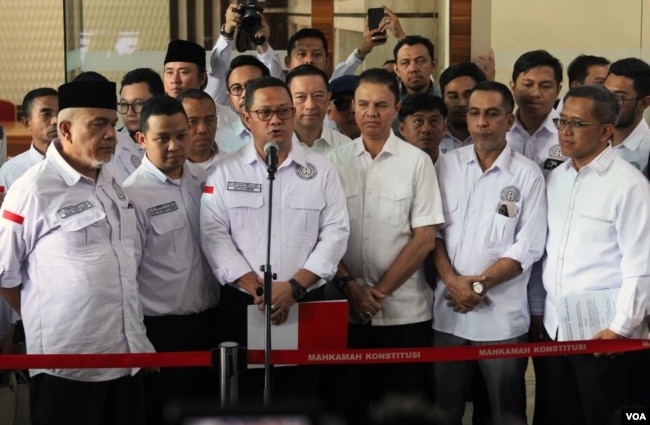 Ketua Tim Kuasa Hukum Paslon Nomor 1, Ari Yusuf Amir (tengah) memberikan keterangan kepada wartawan usai pendaftaran perkara Pemilu Presiden 2024 pada Rabu (20/3) di Gedung MK, Jakarta. (VOA/IndraYoga)