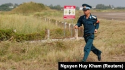 A Vietnamese soldier runs past dioxin contaminated area at the Bien Hoa airbase in Vietnam.