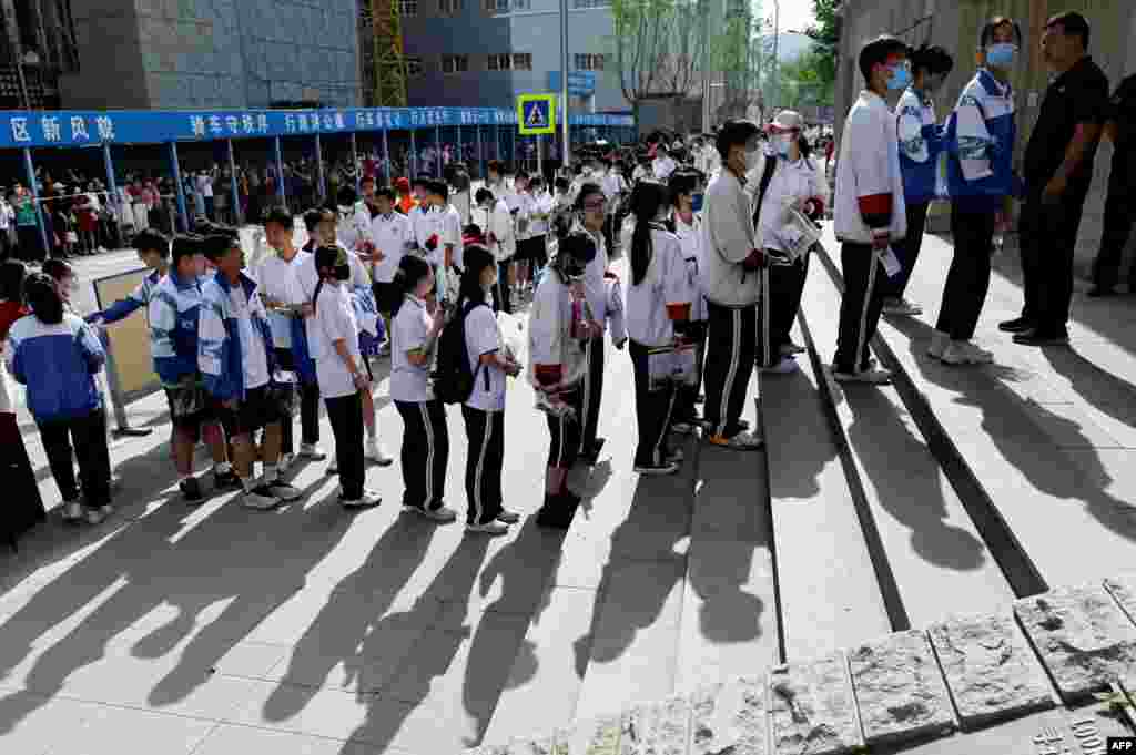 Students line up to enter a school on the first day of China&#39;s national college entrance examination, known as the gaokao, in Beijing.