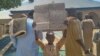 A boy in Kaduna, Nigeria, holds a sign in protest the day after the kidnapping of hundreds of students by gunmen after the Friday prayer in Kaduna, Nigeria, March 8, 2024.