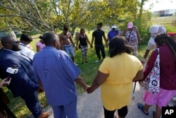 Residents gather for a prayer near the scene of a mass shooting at a Dollar General store in Jacksonville, Florida, Aug. 26, 2023.