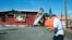 A man walks past a damaged supermarket in Noumea, France's Pacific territory of New Caledonia, on May 24, 2024. 