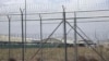 FILE - A hangar can be seen behind barbed wire fencing at Bagram Air Base after the U.S. military left the facility, in Parwan province, north of Kabul, Afghanistan, July 5, 2021.