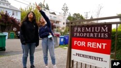 FILE - University of California, Berkeley, freshmen Sanaa Sodhi, right, and Cheryl Tugade look for apartments in Berkeley, Calif., March 29, 2022. 