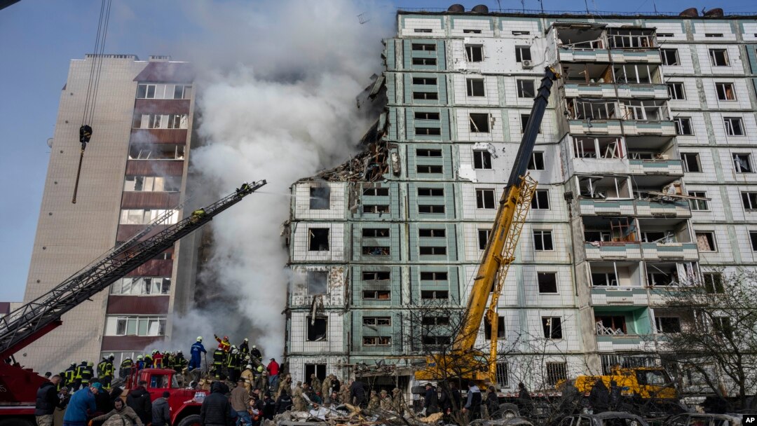 Petugas pemadam kebakaran berupaya memadamkan api setelah serangan Rusia menghantam sebuah bangunan perumahan di Uman, Ukraina tengah, Jumat, 28 April 2023. (AP/Bernat Armangue)