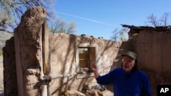 Jake Barrow stands inside a nearly collapsed adobe home he is working to restore in the 1780s Plaza del Cerro square in Chimayo, New Mexico, April 16, 2023. Since it was founded four decades ago, the non-profit Barrow leads, Cornerstones, has helped preserve more than 300 historic churches and other structures in rural northern New Mexico.