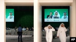 CEO COP28 Adnan Amin (kiri), Presiden COP28 Sultan al-Jaber (tengah), dan Direktur Jenderal Duta Besar COP28 Majid Al Suwaidi, bertepuk tangan di layar saat sesi pleno KTT Iklim PBB COP28, di Dubai, Uni Emirat Arab, Rabu, 13 Desember 2023. (AP/Peter Dejong)