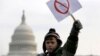 Peyton Tremont, tujuh tahun, melambaikan kertas di tengah aksi protes masyakarat menuntut pengendalian senjata di dekat Capitol AS, Washington, 26 Januari 2013. (Foto: REUTERS/Jonathan Ernst)