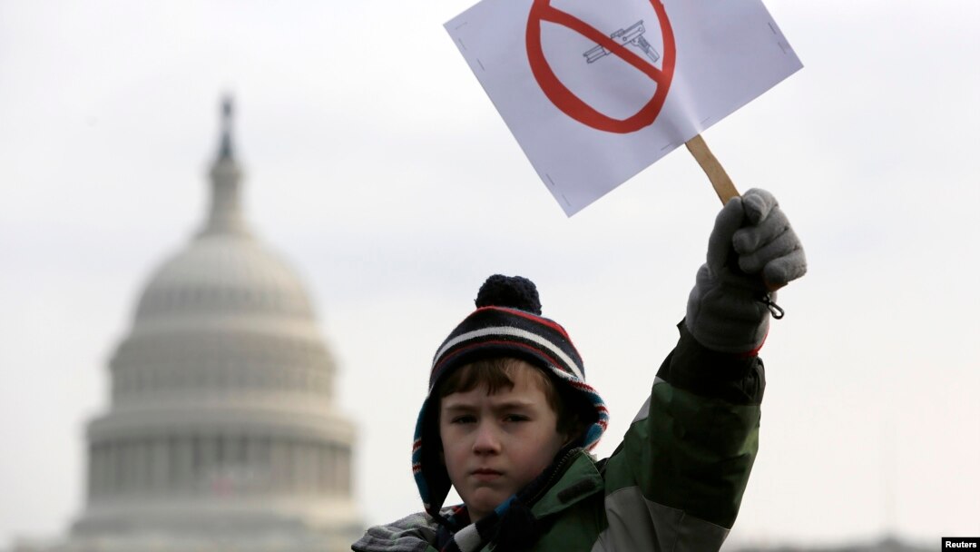 Peyton Tremont, tujuh tahun, melambaikan kertas di tengah aksi protes masyakarat menuntut pengendalian senjata di dekat Capitol AS, Washington, 26 Januari 2013. (Foto: REUTERS/Jonathan Ernst)