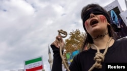 FILE - A protester holds a rope as writing on her neck reads "#no to the death penalty" during a rally in support of anti-government protesters in Iran, in Istanbul, Turkey, Nov. 19, 2022. A U.N. report released June 21, 2024, criticizes the high number of executions in Iran.