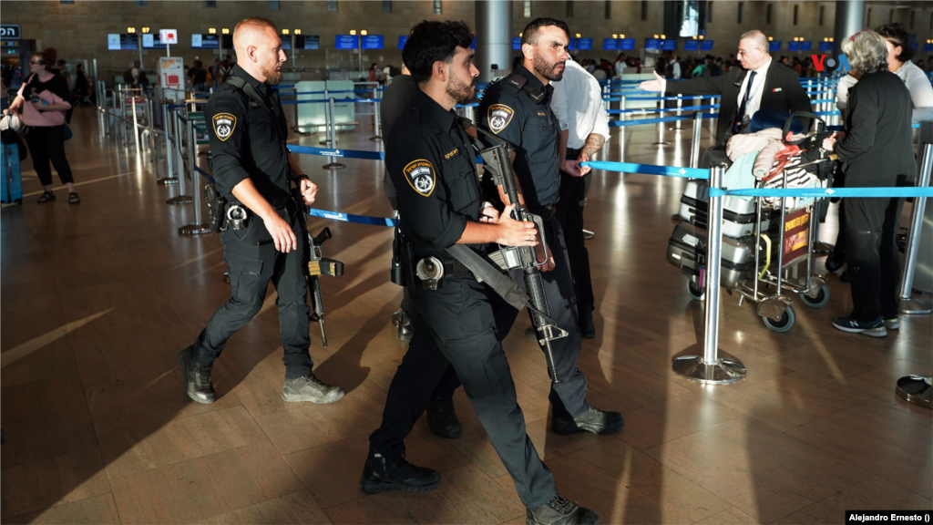 Militares israelíes con fusiles custodian el aeropuerto internacional de Telaviv en el que turistas y ciudadanos extranjeros esperan para abordar vuelos de repatriación de regreso a sus países, el 13 de octubre de 2023.