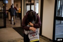 Kelsey Lefond comforts her son after he arrived with his father from Yellowknife on a plane coming from the Northwest Territories, Aug. 18, 2023, in Edmonton, Alberta. Yellowknife was given an evacuation order because of area wildfires.