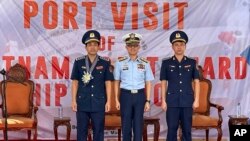 Colonel Hoang Quoc Dat, vice Commander of Vietnam Coast Guard Region 2, from left, Philippine Coast Guard Commodore Arnaldo Lim and Captain Le Xuan Truong, pose for a photo in Manila, Aug. 5, 2024.