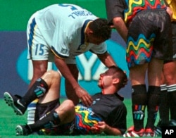 FILE - Miami Fusion's Tyrone Marshall (15) assists Kansas City Wizards' Scott Vermillion after the two collided while going up for a header in the first half of a soccer match Aug. 29, 1999, in Kansas City, Mo.