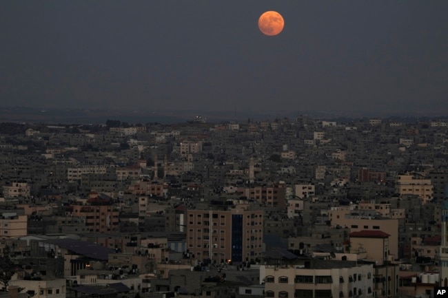 The supermoon rises in the sky over the houses of Gaza City, Wednesday, Aug. 30, 2023. (AP Photo/Adel Hana)