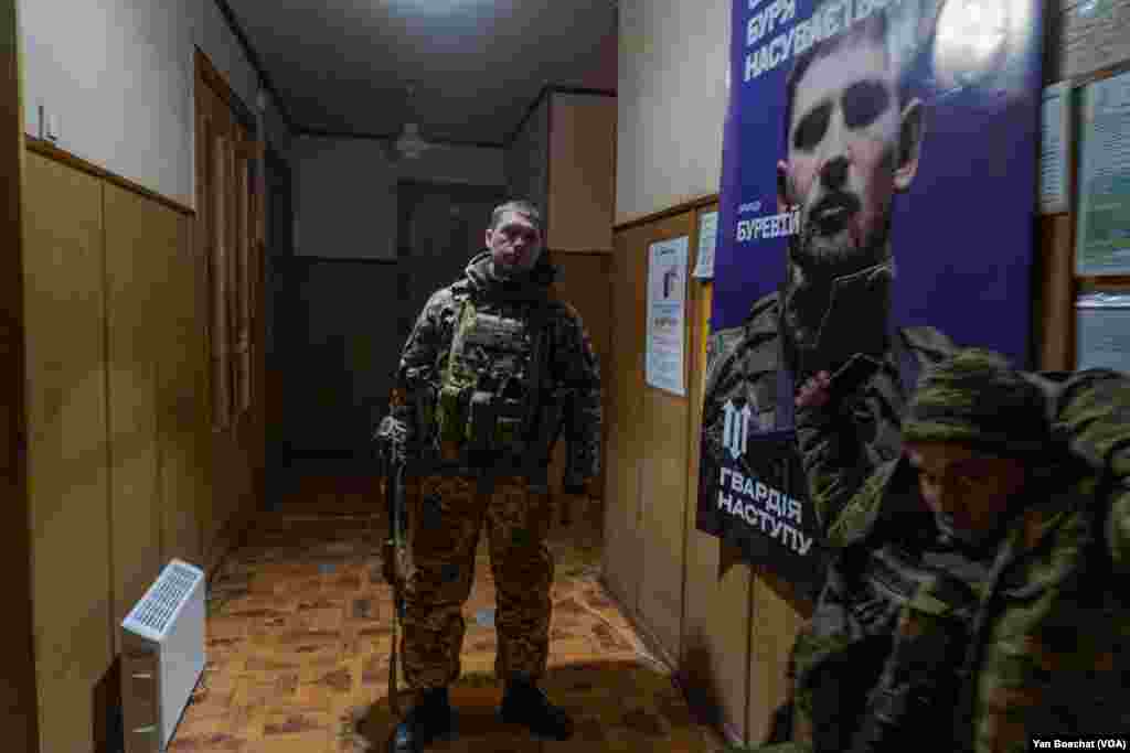 Armed soldiers protect the mayor and city hall employees in Kupiansk, Feb. 16, 2023.