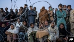 FILE - Afghan refugees wait to register in a camp near the Torkham Pakistan-Afghanistan border in Torkham, Afghanistan, Nov. 4, 2023. 