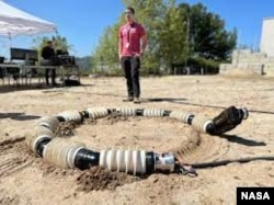 EELS is tested in the sandy terrain of JPL's Mars Yard in April. Engineers repeatedly test the snake-like robot across a variety of terrain, including sand, snow and ice. (Photo Credit: NASA/JPL-Caltech)