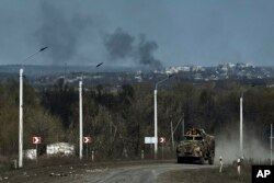 Sebuah kendaraan militer Ukraina tampak melintas di jalan garis depan di Bakhmut, wilayah Donetsk, 9 April 2023. (Foto: Libkos/AP Photo)