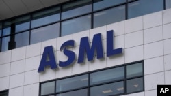 FILE - The logo of ASML, a leading maker of semiconductor production equipment, hangs on the head office in Veldhoven, Netherlands, Jan. 30, 2023. ASML dominates the global market for lithography systems, which use lasers to help create chip circuitry.
