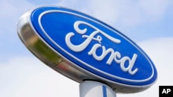 FILE - A Ford sign is shown at a dealership in Springfield, Pennsylvania., April 26, 2022. Ford is recalling nearly 243,000 Maverick small pickup trucks in the U.S. because the tail lights may not illuminate.