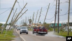 FILE - Power lines bend toward the road after Hurricane Zeta hit Grand Isle, in the U.S. state of Louisiana, Oct. 30, 2020.