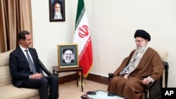 Iran's Supreme Leader Ayatollah Ali Khamenei, right, speaks with Syrian President Bashar Assad during their meeting in Tehran, May 30, 2024. A portrait of the late President Ebrahim Raisi is seen between them. (Office of the Iranian Supreme Leader via AP)