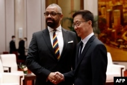 FILE - British Foreign Secretary James Cleverly, left, and Chinese Vice President Han Zheng shake hands before a meeting at the Great Hall of the People in Beijing, Aug. 30, 2023.