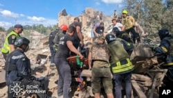 Emergency workers clear rubble as they search for victims after a Russian missile hit the area, in Kryvyi Rih, Ukraine, June 12, 2024. (Ukrainian Emergency Service via AP)