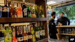 People buy alcohol in a liquor store in Baghdad, Iraq, March 9, 2023. The Iraqi government started enforcing a 2016 ban on alcoholic beverages this month, although many liquor shops remained open in Baghdad.