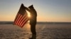 Christophe Receveur, de Francia, despliega una bandera estadounidense que compró hace seis meses en Gettysburg, Pensilvania, para conmemorar el Día D, el jueves 6 de junio de 2024 en Utah Beach, Normandía.
