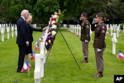 President Joe Biden and first lady Jill Biden stand before a wreath at the Normandy American Cemetery following a ceremony to mark the 80th anniversary of D-Day, June 6, 2024, in Normandy, France.