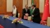 Iranian security council official Ali Shamkhani shakes hands with China's senior foreign policy official Wang Yi as Saudi security adviser Musaad bin Mohammed al-Aiban watches during a signing of an accord to reset Iranian-Saudi ties, in Beijing, March 10, 2023. (Nournews via AP)
