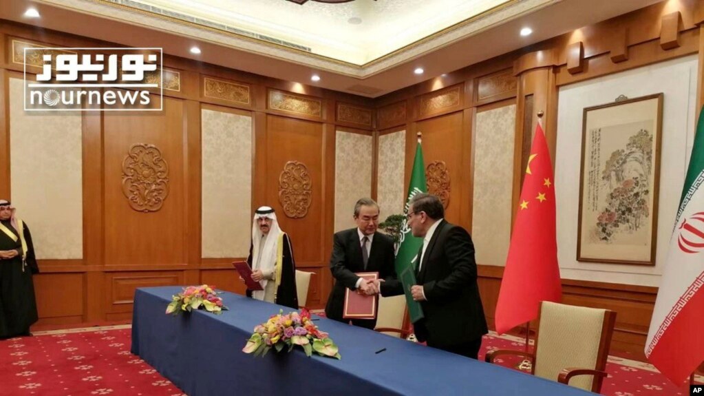 2023年3月10日，伊朗最高国家安全委员会秘书阿里·沙姆哈尼（右）在北京的会谈结束后同中共外事主管王毅握手。照片最左边是沙特国务大臣、内阁成员和国家安全顾问穆萨伊德·本·穆罕默德·艾班。(photo:VOA)