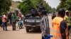 FILE - Police officers drive on a vehicle during a protest called to draw attention to the jihadist threat, in Ouagadougou, Burkina Faso, July 3, 2021. 