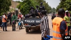 FILE - Police officers drive on a vehicle during a protest called to draw attention to the jihadist threat, in Ouagadougou, Burkina Faso, July 3, 2021. 