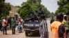 FILE - Police officers drive on a vehicle during a protest called to draw attention to the jihadist threat, in Ouagadougou, Burkina Faso, July 3, 2021. 
