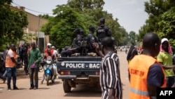 FILE - Police officers drive on a vehicle during a protest called to draw attention to the jihadist threat, in Ouagadougou, Burkina Faso. RTaken July 3, 2021. 