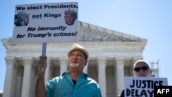 People hold anti-Trump signs in front of the U.S. Supreme Court on July 1, 2024, in Washington after the court ruled that presidents have presumptive immunity for official acts.