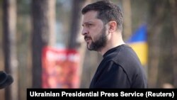 Ukraine's President Volodymyr Zelenskyy sings a national anthem during a commemorative ceremony for Ukrainian servicemen killed in battle for the village of Moshchun in Ukraine, March 21, 2023. (Photo from Ukrainian Presidential Press Service/Handout via Reuters)