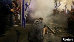 A demonstrator sits during a protest in Tel Aviv, Israel, against Israeli Prime Minister Benjamin Netanyahu's government and call for the release of hostages kidnapped in Hamas' deadly October 7 attack on Israel, March 30, 2024