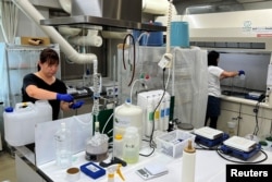 Members of Tarachine measure radiation levels in collected seawater at their lab in Iwaki, Fukushima Prefecture, Japan, Aug. 8, 2023.
