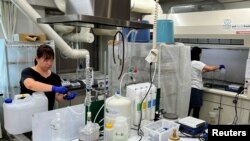 FILE - Members of Tarachine measure radiation levels in collected seawater at their lab in Iwaki, Fukushima Prefecture, Japan, Aug. 8, 2023.