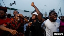 People cheer after poll workers announced results at their polling unit in Awka, Anambra state, Nigeria, Feb. 25, 2023. By evening, some polling stations were already counting ballots while voting was still going on at others and had not taken place elsewhere. 
